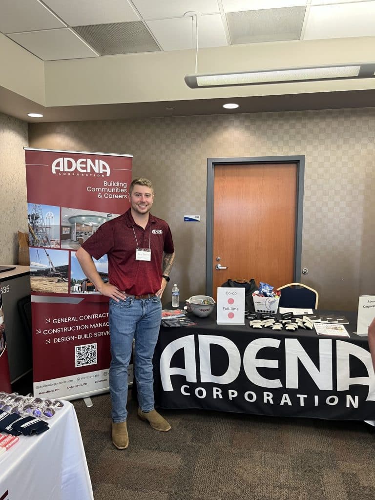 Adena employee sat a trade show infront of the Adena booth.